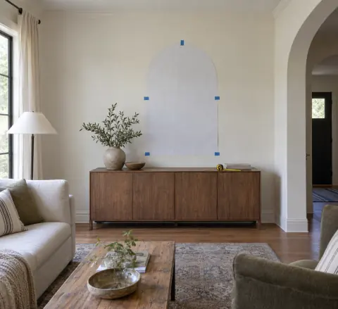Gabarit de miroir arqué en papier fixé sur un mur au-dessus d’un buffet