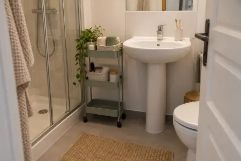 Desserte étroite à roulettes et paniers près d’un lavabo de location avec passage libre